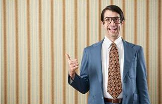 Nerdy guy wearing glasses, smiling and making a thumbs up gesture.